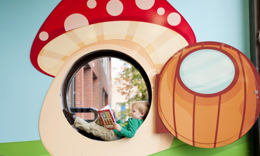 Child reading inside mushroom cutout